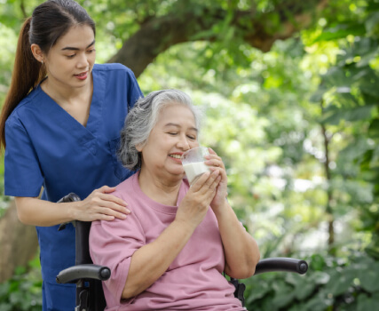 Caregiver helping senior woman with comfort and daily care outdoors