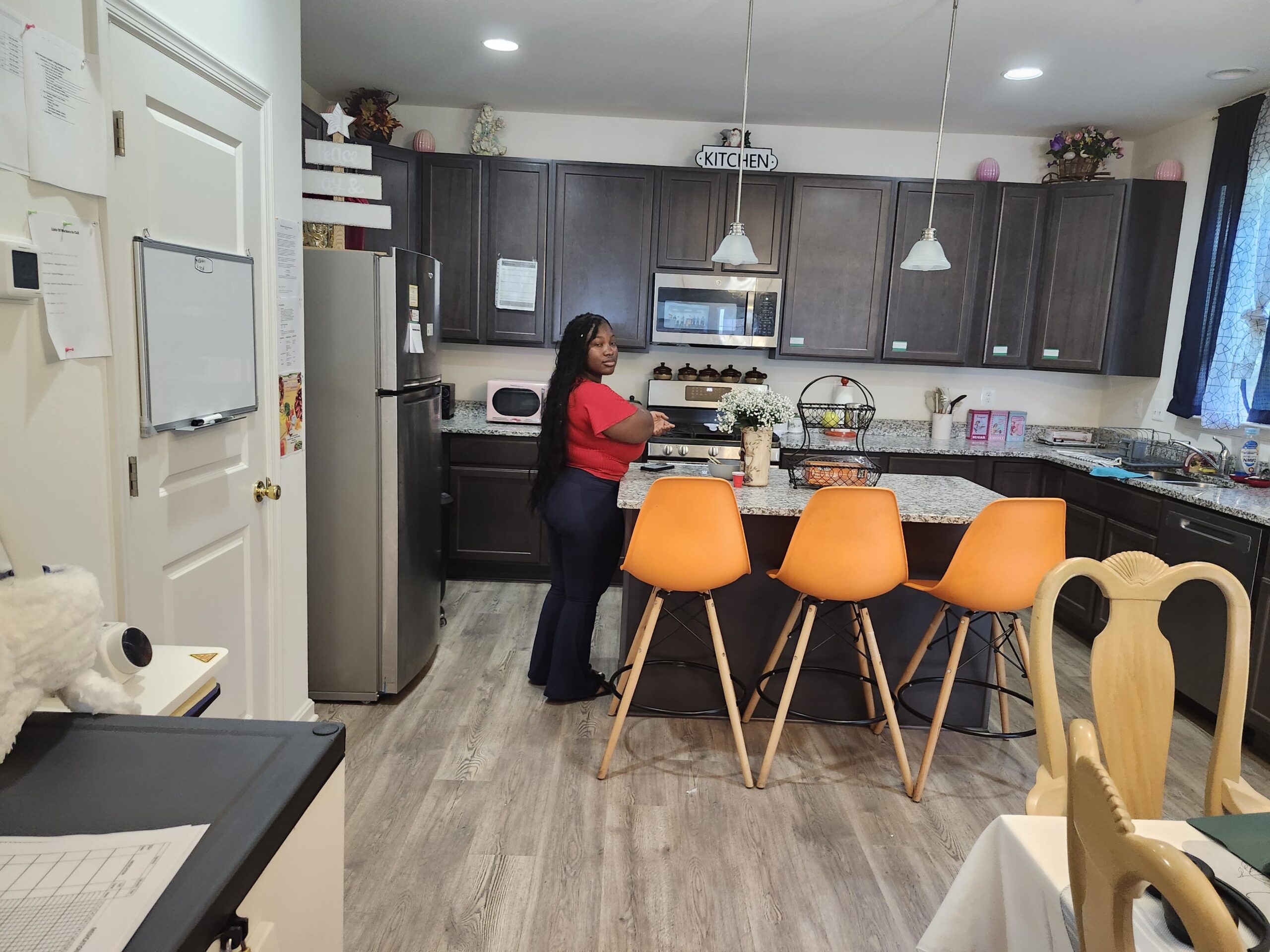 Assisted living kitchen area with caregiver preparing meals